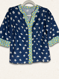 Blue patterned blouse with yellow accents on a white background