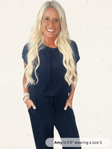Woman wearing a navy blue outfit with text indicating height and shoe size.