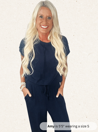 Woman wearing a navy blue outfit with text indicating height and shoe size.
