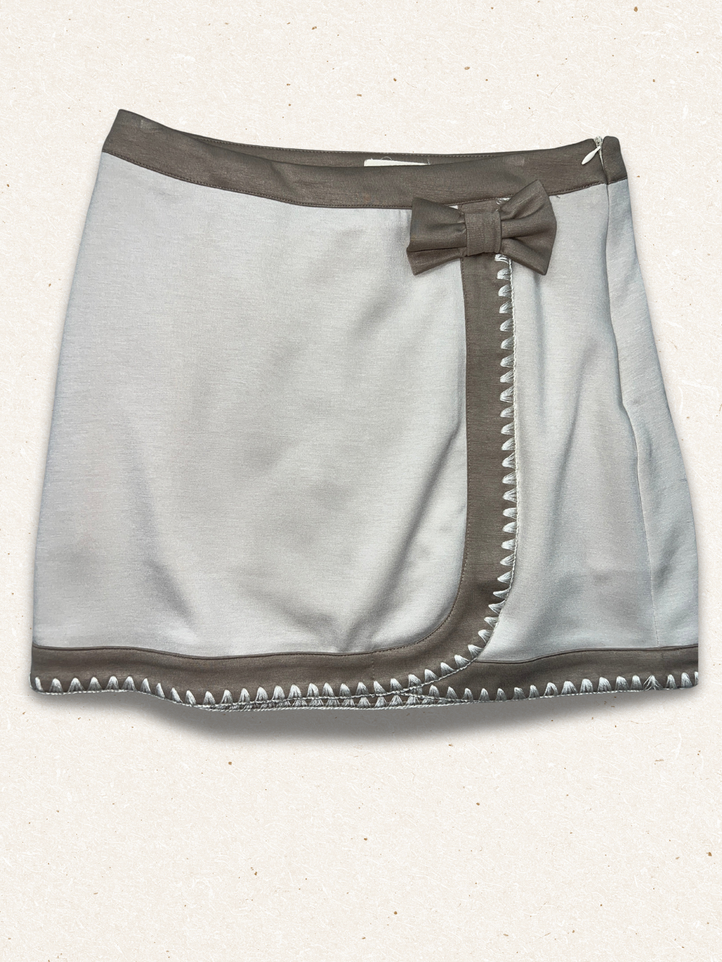 Gray skirt with a bow and stud details on a white background