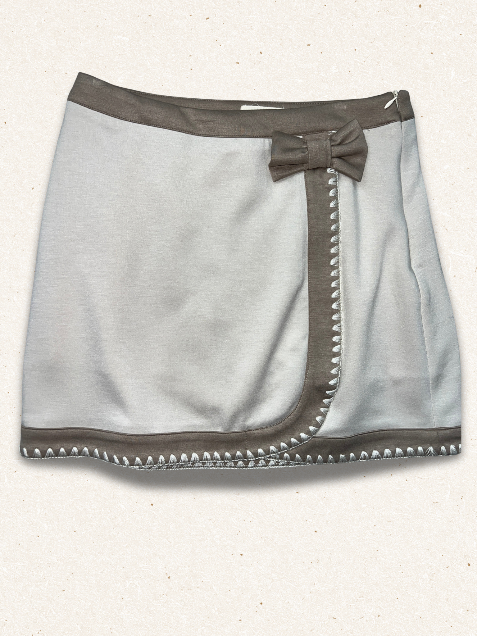 Gray skirt with a bow and stud details on a white background