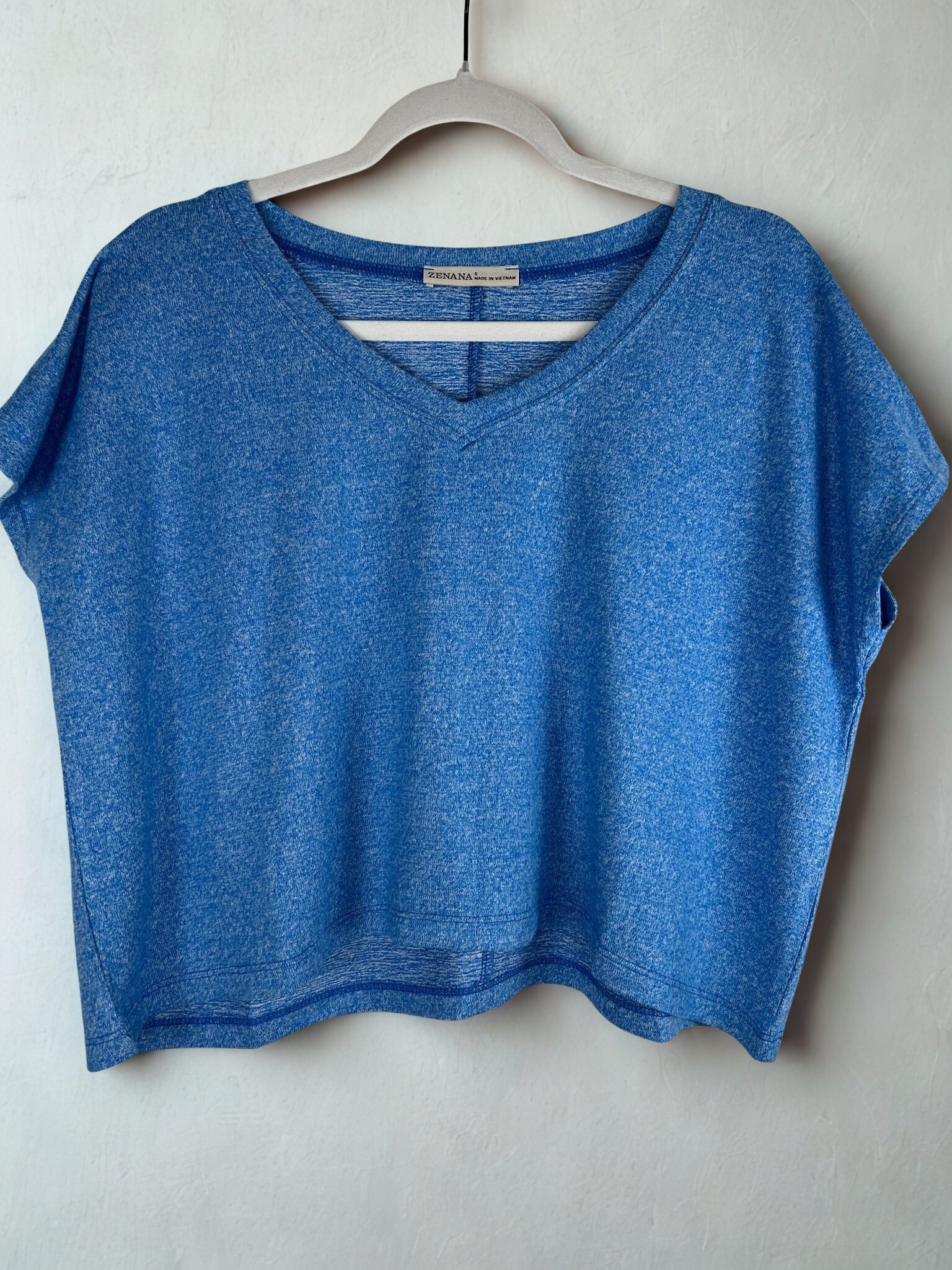 /Blue/ Blue crop top on a hanger against a white background