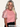 Woman wearing a pink top with sheer sleeves on a white background