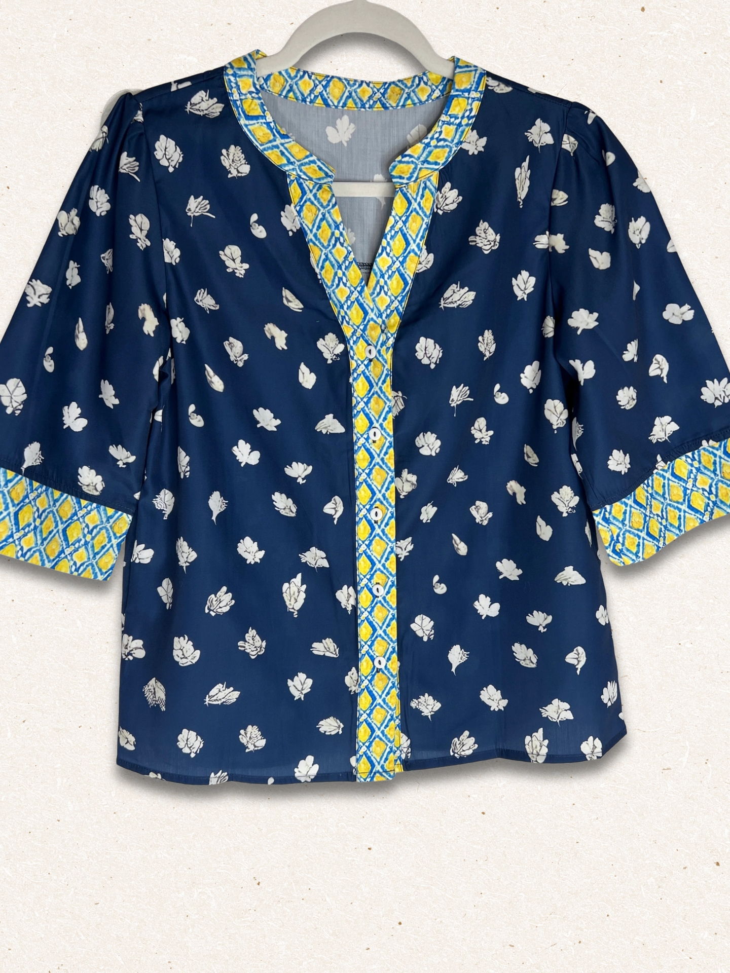 Blue patterned blouse with yellow accents on a white background