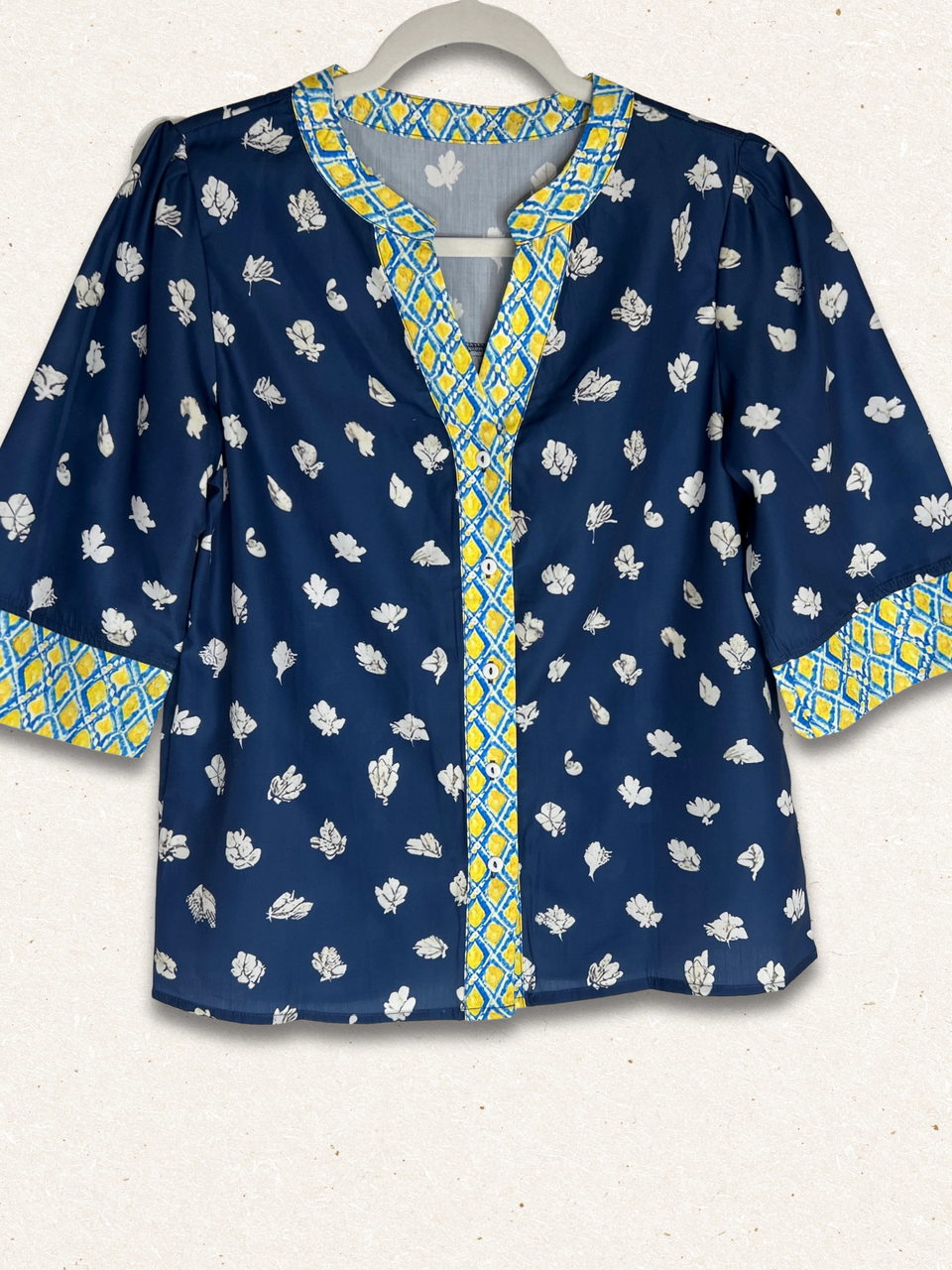 Blue patterned blouse with yellow accents on a white background