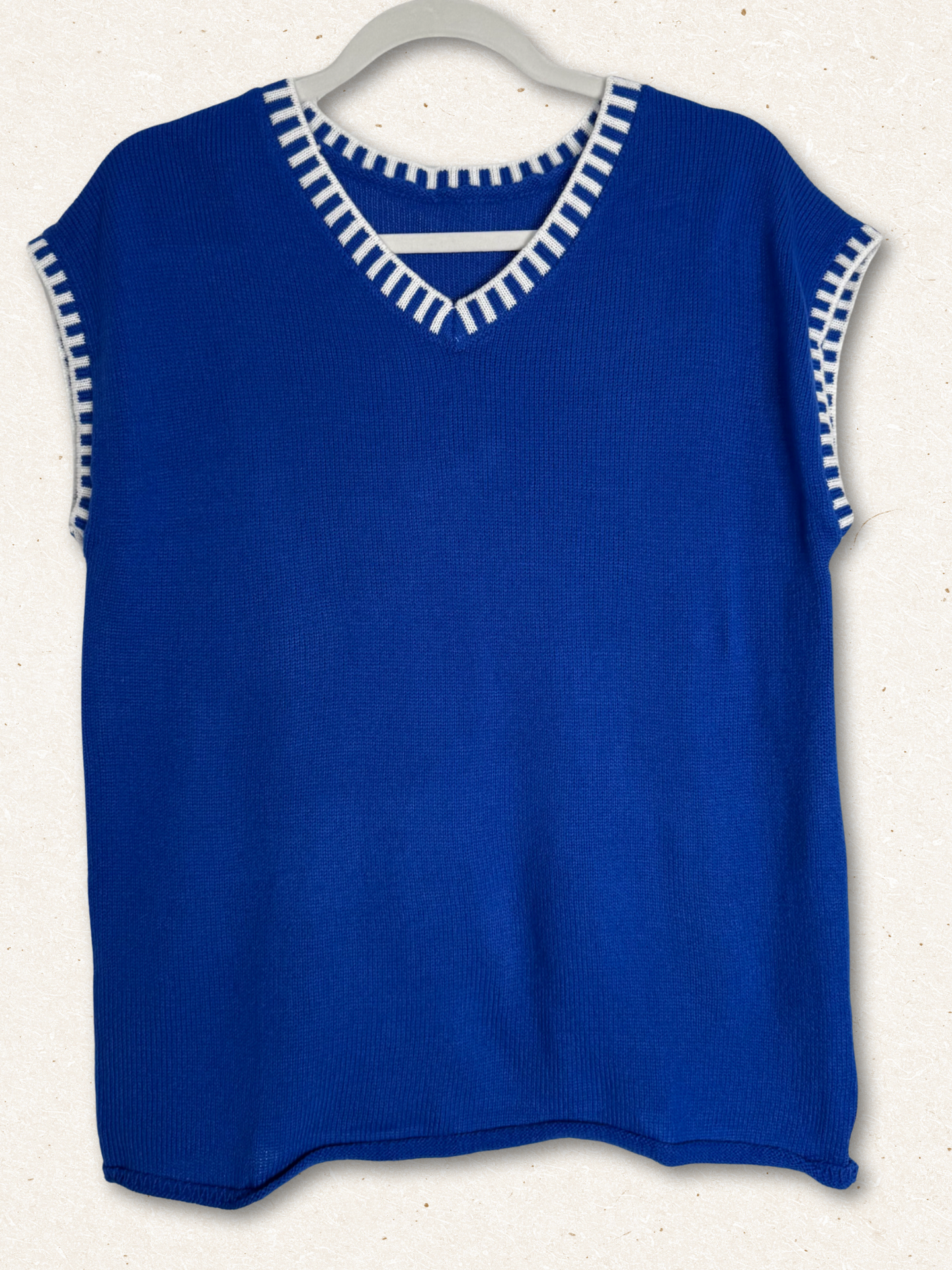 /Blue/ sleeveless top with white trim on a hanger against a white background