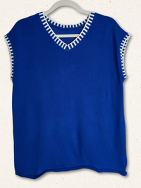 /Blue/ sleeveless top with white trim on a hanger against a white background
