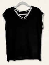 /Black/ Black sleeveless top with white trim on a hanger against a white background