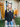 Woman standing in front of a house with Halloween decorations, including a 'Welcome' sign and pumpkins.