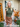 Woman wearing a green sweater and brown leather skirt standing in front of a 'Welcome' sign.