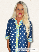 Woman wearing a blue patterned shirt with text indicating height and size.