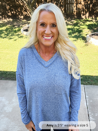 Woman wearing a blue sweater outdoors on a sunny day