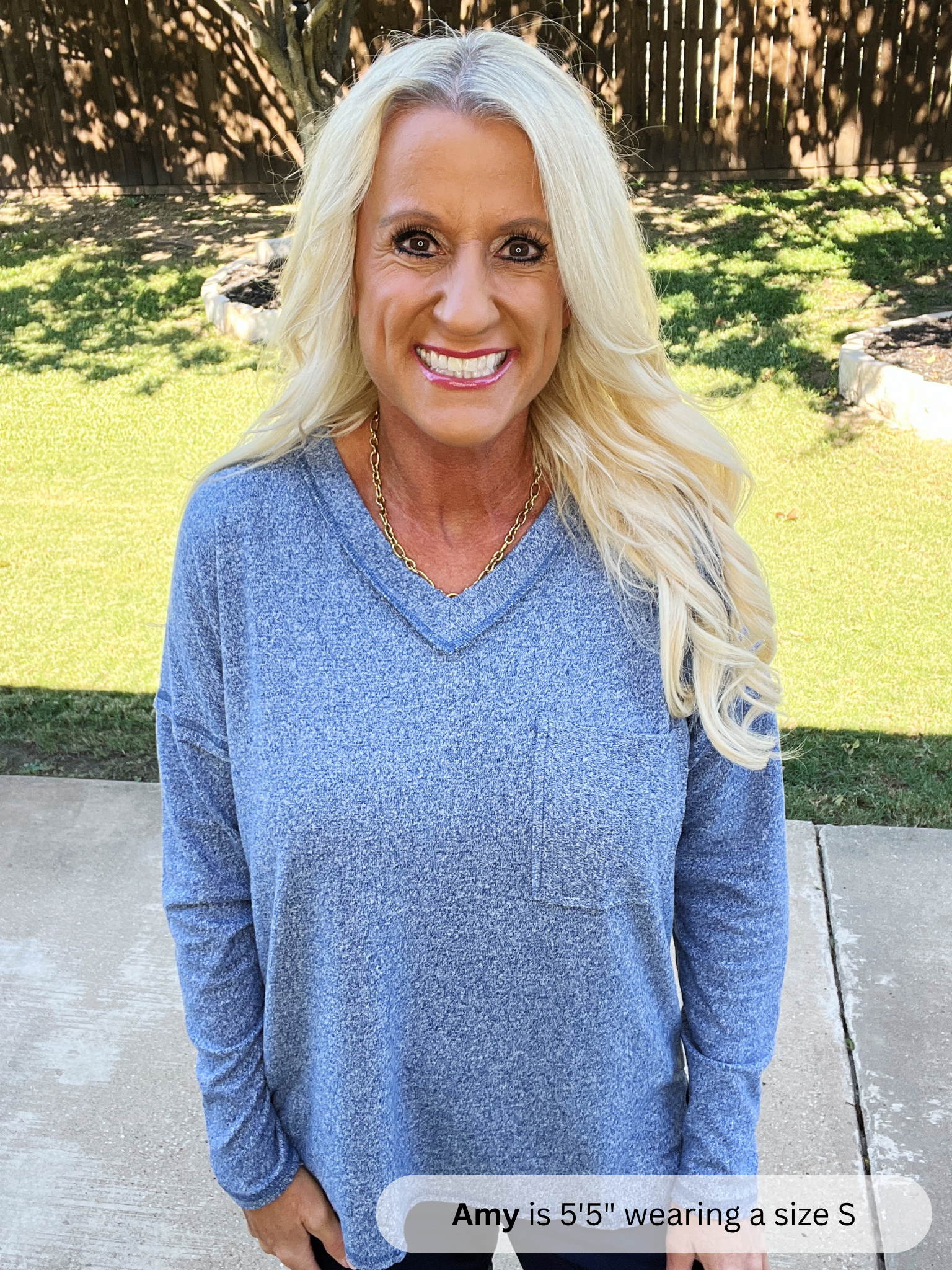 Woman wearing a blue sweater outdoors on a sunny day