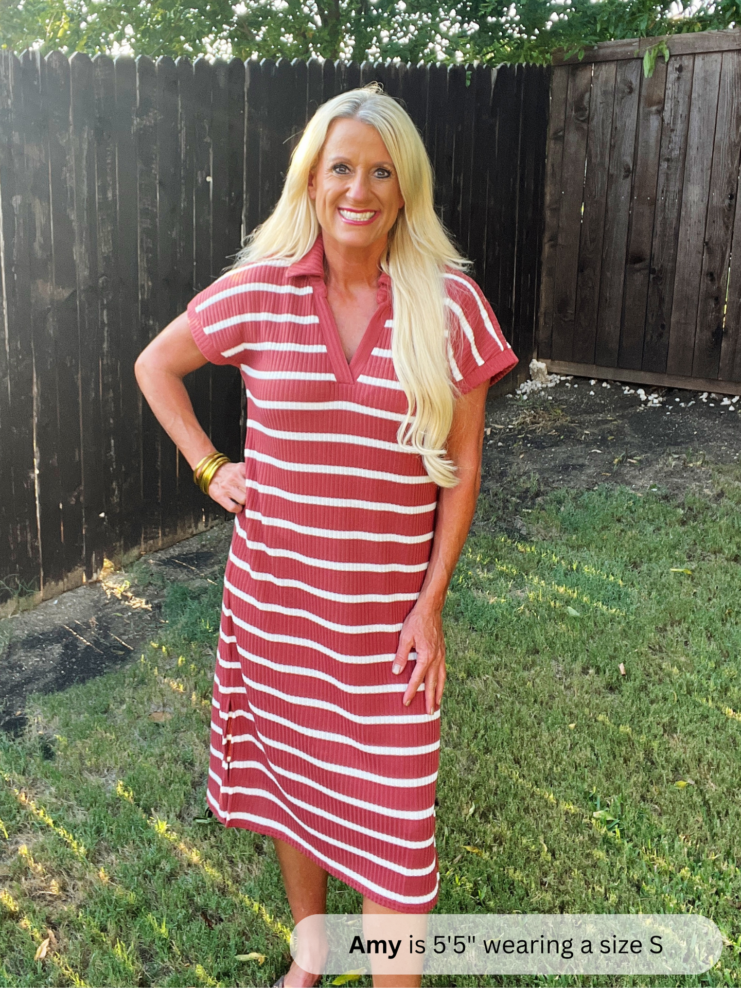 Woman wearing a red and white striped dress standing outdoors.