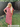 Woman wearing a red and white striped dress standing outdoors.