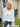 Woman wearing a floral blouse standing outside a house