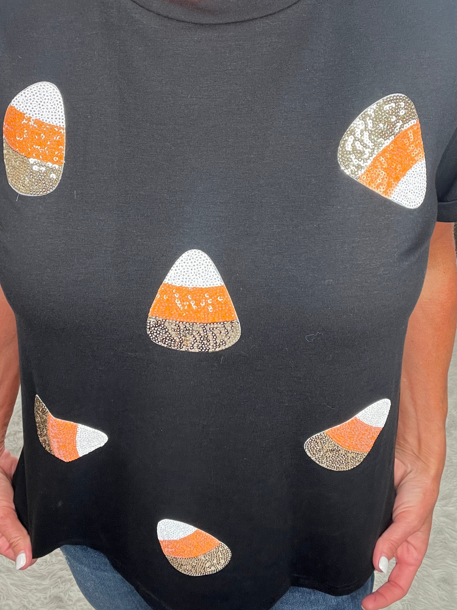 Black t-shirt with candy corn pattern worn by a person