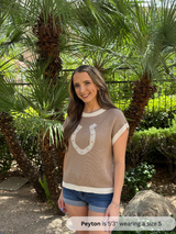 /Cream/ Woman wearing a brown sweater with a horseshoe design in a garden setting