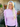 Woman wearing a light purple turtleneck sweater standing outside a house.