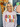 Woman wearing a 'Gobble Gobble' shirt in front of a decorated door with pumpkins and autumn decorations.