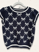 Navy blue sweater with white bow pattern on a white background