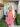 /Rust/ Woman wearing a black top and blue jeans with a white curtain background