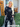 Woman wearing a black outfit with white star patterns standing outside a house.