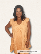 Woman wearing a peach-colored dress on a light background