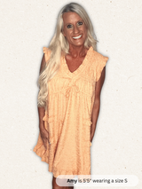 Woman wearing a peach-colored dress on a white background