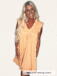 Woman wearing a peach-colored dress on a white background