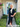 Woman in a black dress standing in front of a house with decorative signs.