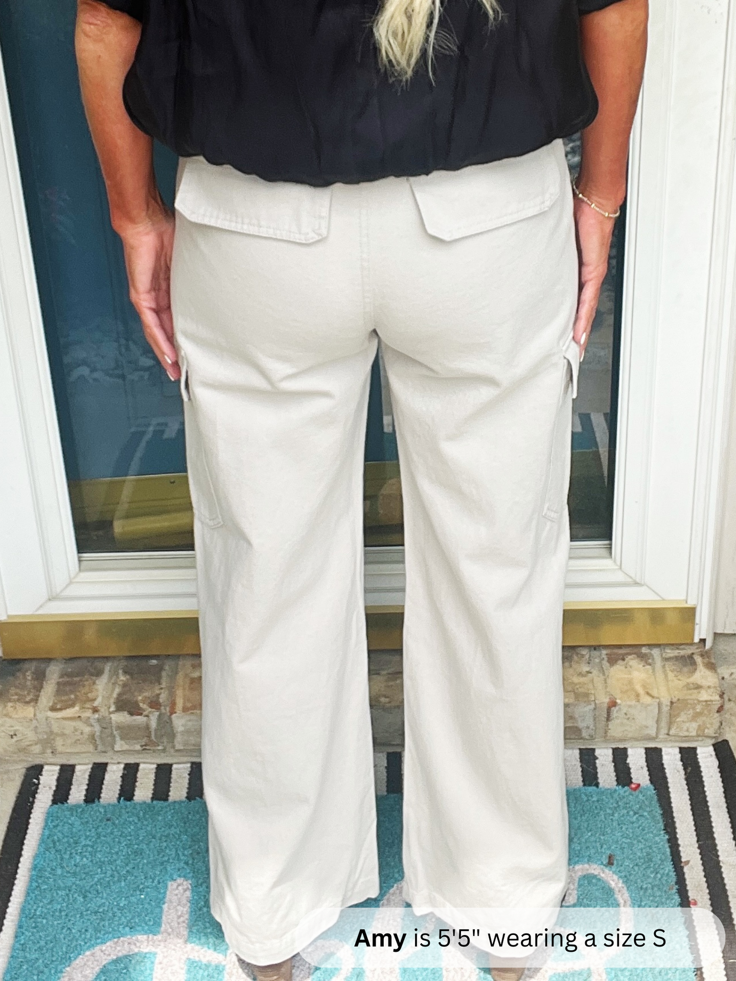 Person wearing light-colored pants and a black top indoors.
