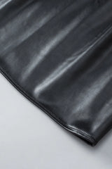 Close-up of the Kara Top by Lovesoft in shiny black faux leather, fully lined for comfort. The smooth texture, subtle reflections, and neat edge stitching are shown as it lies on a light gray surface.