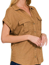 Woman wearing a brown sleeveless shirt with pockets on a white background
