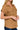 Woman wearing a brown sleeveless shirt with pockets on a white background